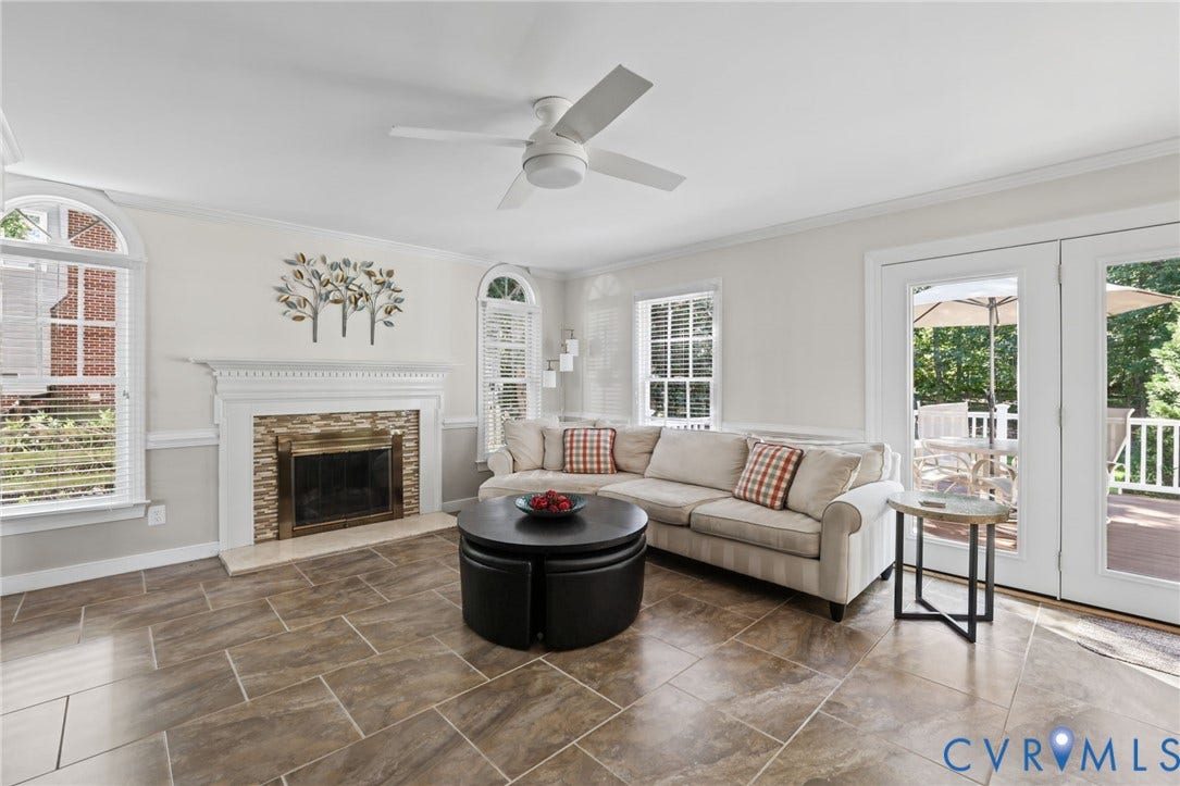 Gas fireplace with stone surround, double arched windows.