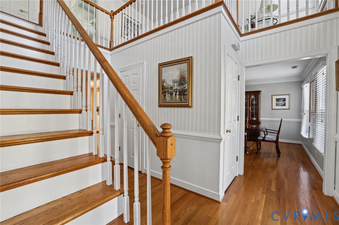 Hardwood staircase with white risers and wood banister