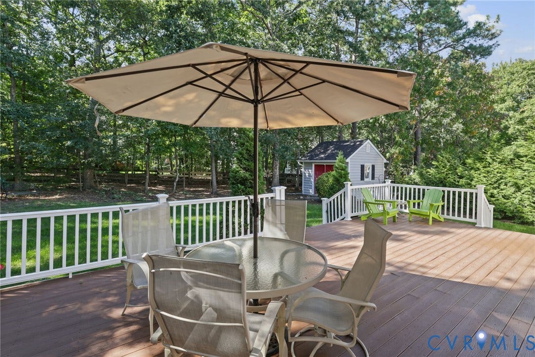 Spacious outdoor deck with composite decking, white railing, and mature tree landscaping