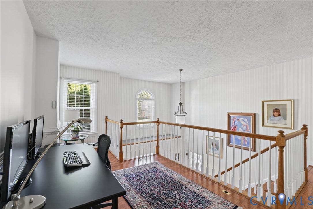Office area - Wood-look laminate flooring, baluster railing, arched window, chandelier lighting, and a window with blinds