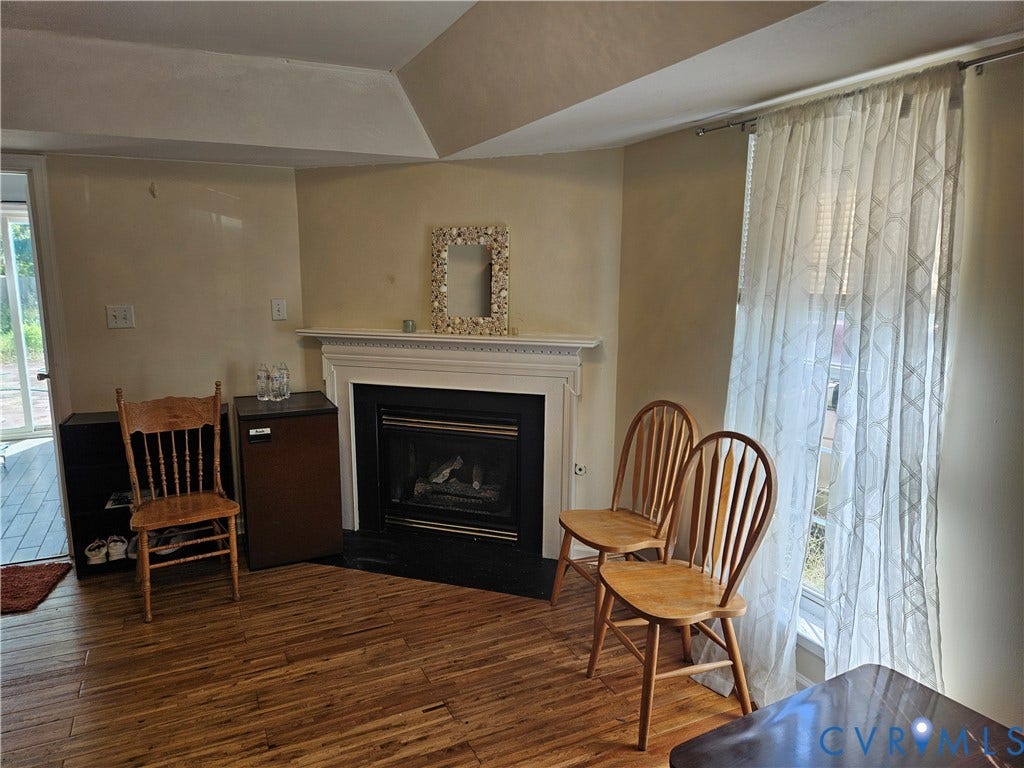 1307 Spruance Road, Outten Woods, Richmond, VA 23225 Wood-finish flooring, white mantel, fireplace with black surround, and sliding glass door