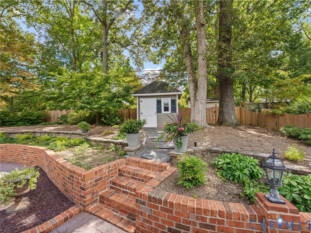 7723 Stuart Hall Road, Rollingwood Terrace, Henrico, VA 23229 Terraced landscaping with brick retaining walls, integrated brick steps, a detached storage shed, and mature trees
