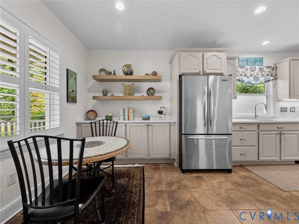 7723 Stuart Hall Road, Rollingwood Terrace, Henrico, VA 23229 Stainless steel refrigerator, white shaker-style cabinetry, wood-finish flooring, white plantation shutters, and recessed lighting