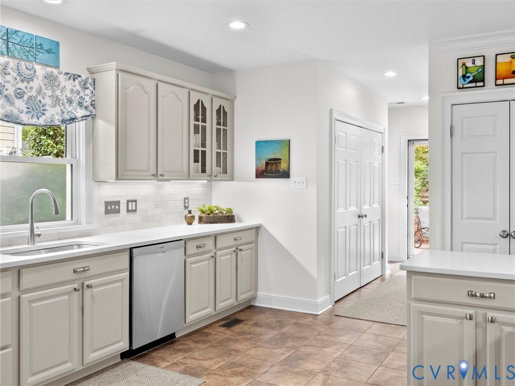 7723 Stuart Hall Road, Rollingwood Terrace, Henrico, VA 23229 Kitchen featuring light-toned cabinetry, white countertops, subway tile backsplash, and a stainless steel dishwasher