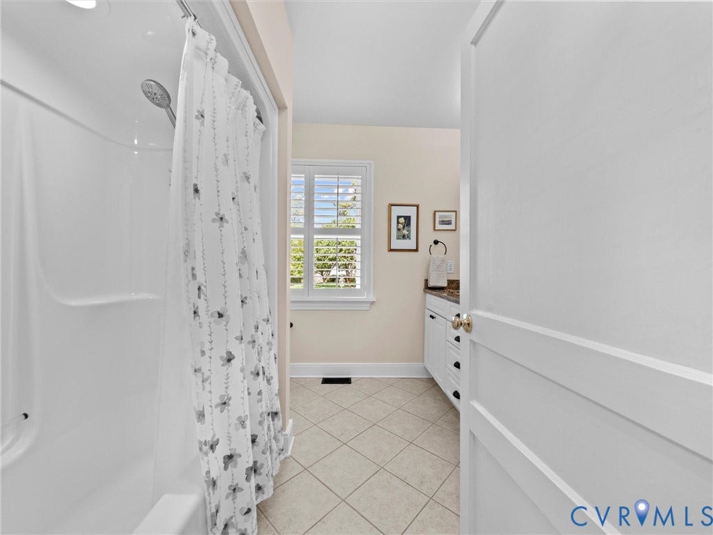 7723 Stuart Hall Road, Rollingwood Terrace, Henrico, VA 23229 Ceramic tile flooring, white shaker-style vanity with dark hardware, granite countertop, and a window with plantation shutters