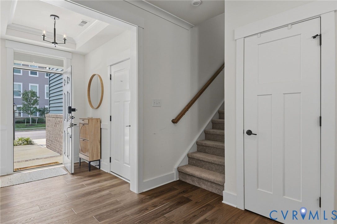 6142 Jackline Run, Watermark, Chesterfield, VA 23234 Wood-finish flooring, recessed ceiling with a chandelier, white paneled doors, and carpeted staircase with a wood handrail
