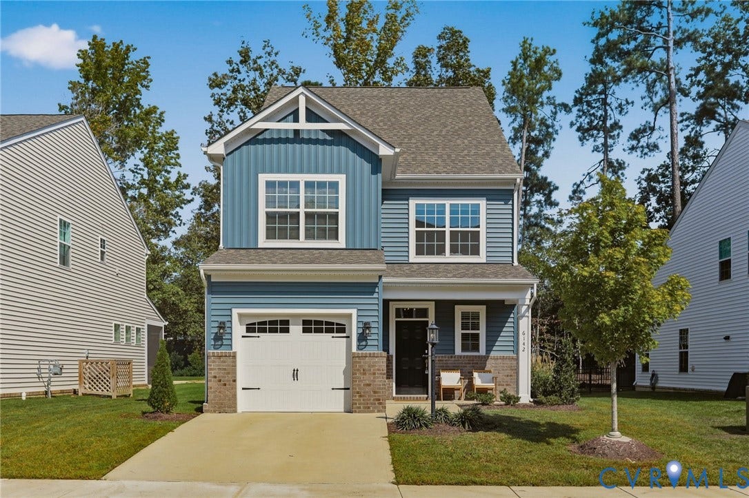 6142 Jackline Run, Watermark, Chesterfield, VA 23234 Two-story residence featuring blue siding with brick accents, an attached garage, a covered front porch, and a manicured lawn