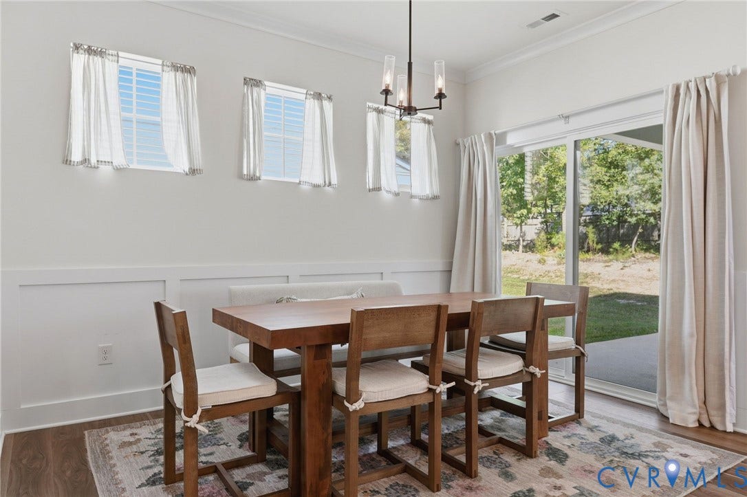 6142 Jackline Run, Watermark, Chesterfield, VA 23234 Hardwood-style flooring, white wainscoting, sliding glass door, crown molding, and a contemporary chandelier