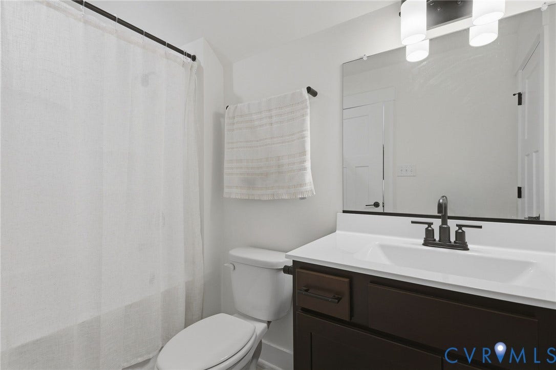 6142 Jackline Run, Watermark, Chesterfield, VA 23234 Dark wood-finish vanity with white countertop, integrated sink, and dark-toned fixtures