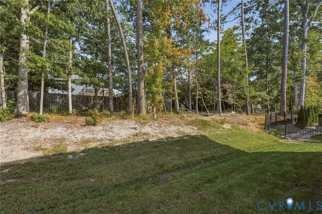 6142 Jackline Run, Watermark, Chesterfield, VA 23234 Expansive backyard featuring a manicured lawn, established trees, and a privacy fence