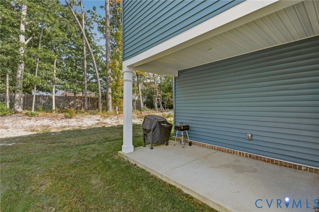 6142 Jackline Run, Watermark, Chesterfield, VA 23234 Covered concrete patio with a white support column, blue horizontal siding, and brick accent foundation