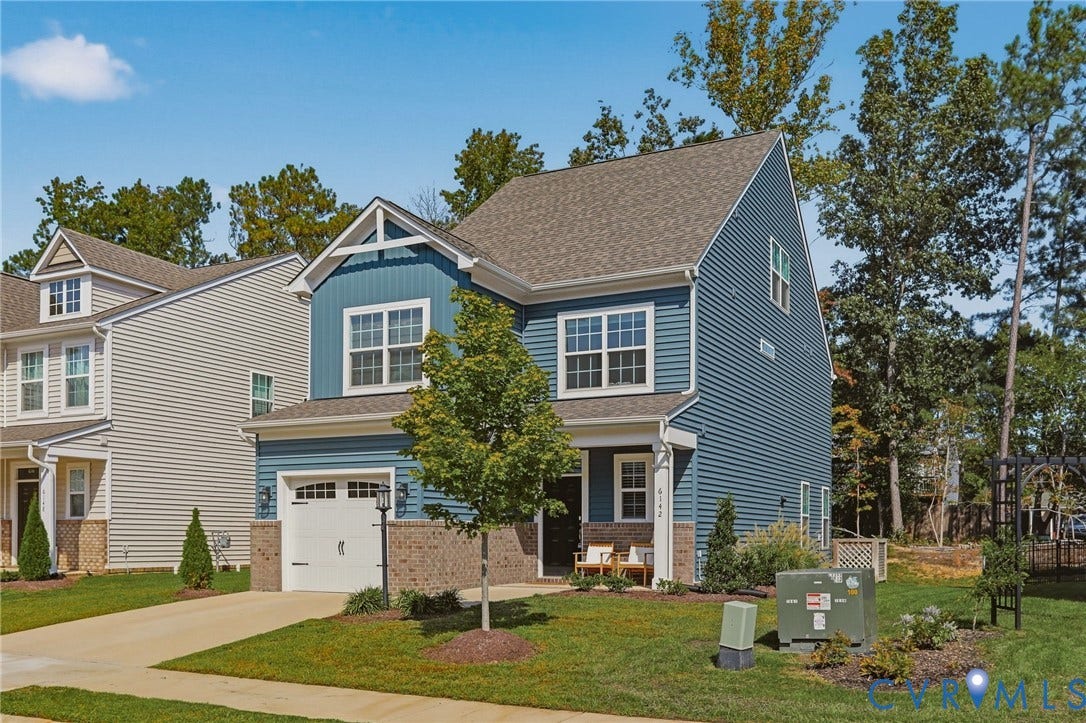 6142 Jackline Run, Watermark, Chesterfield, VA 23234 Two-story residence featuring blue siding, brick accents, a gabled roof, and a single-car garage with a panel door