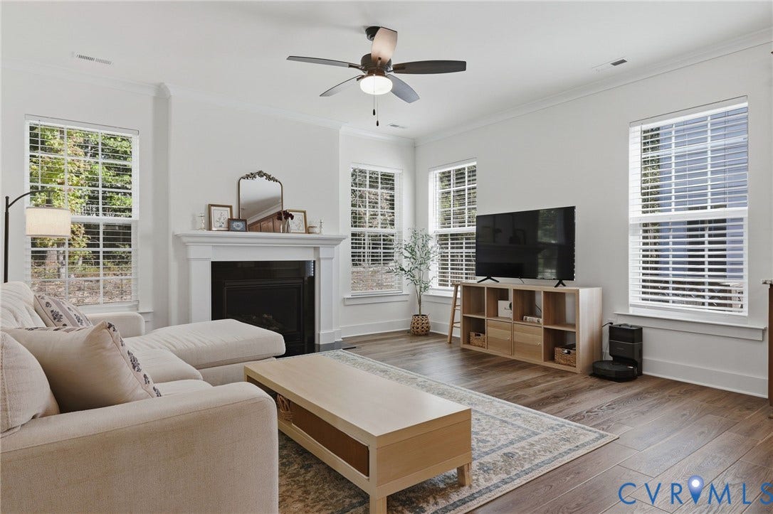 6142 Jackline Run, Watermark, Chesterfield, VA 23234 White walls with crown molding, wood-finish flooring, recessed fireplace with mantel, ceiling fan, and multiple windows