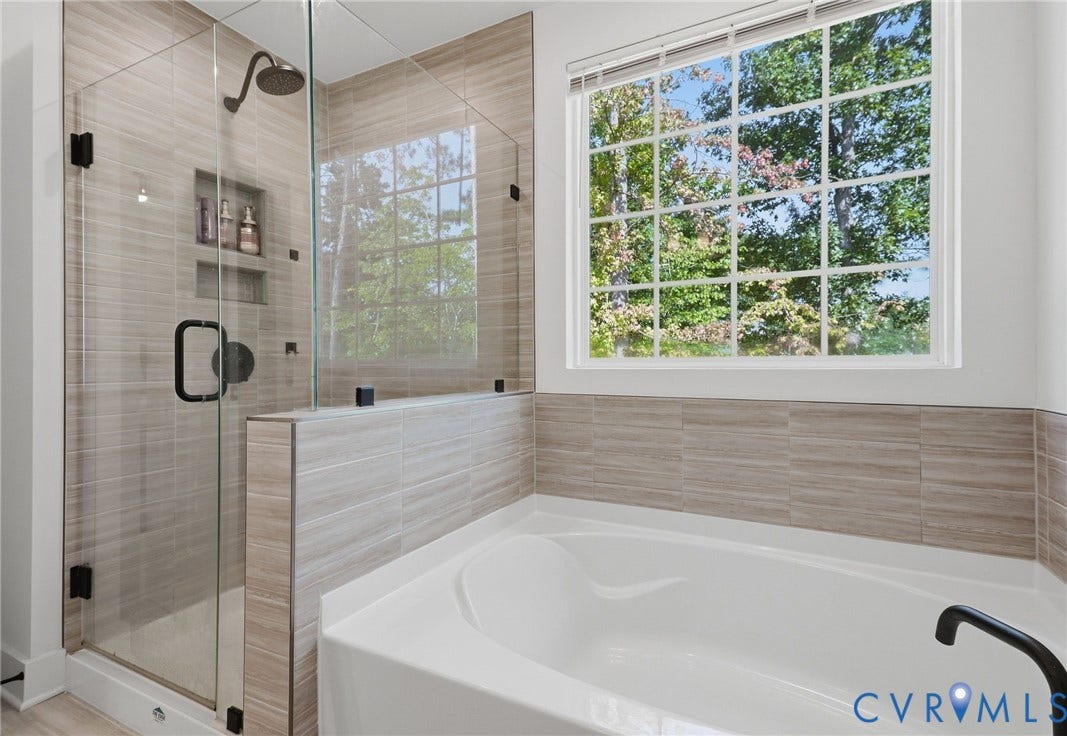 6142 Jackline Run, Watermark, Chesterfield, VA 23234 Soaking tub and glass-enclosed shower featuring a rain showerhead, tiled walls, and built-in shelving