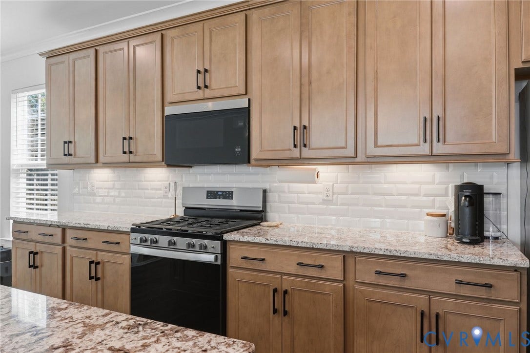 6142 Jackline Run, Watermark, Chesterfield, VA 23234 Kitchen featuring wood-finish cabinetry, granite countertops, white subway tile backsplash, stainless steel range, and a built-in microwave