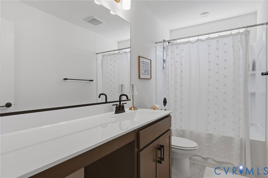 6142 Jackline Run, Watermark, Chesterfield, VA 23234 Vanity with integrated sink, matte black faucet, and wood-finish cabinetry