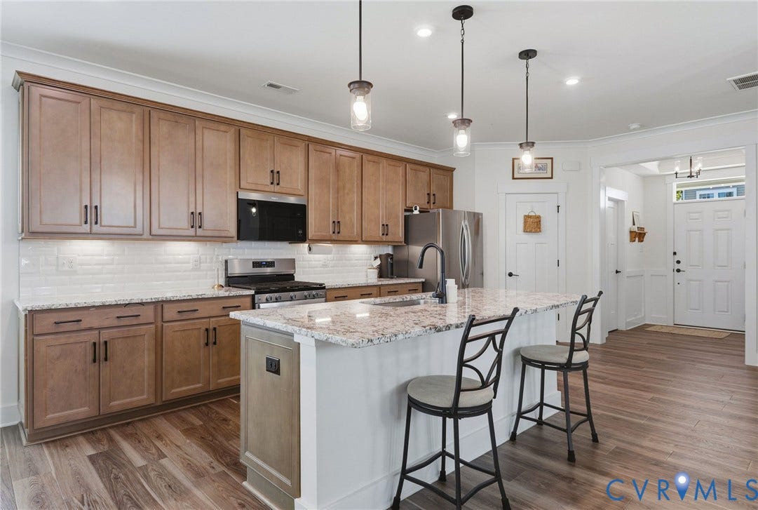 6142 Jackline Run, Watermark, Chesterfield, VA 23234 Wood-finish flooring, recessed lighting, and a white subway tile backsplash complement the full suite of stainless steel appliances