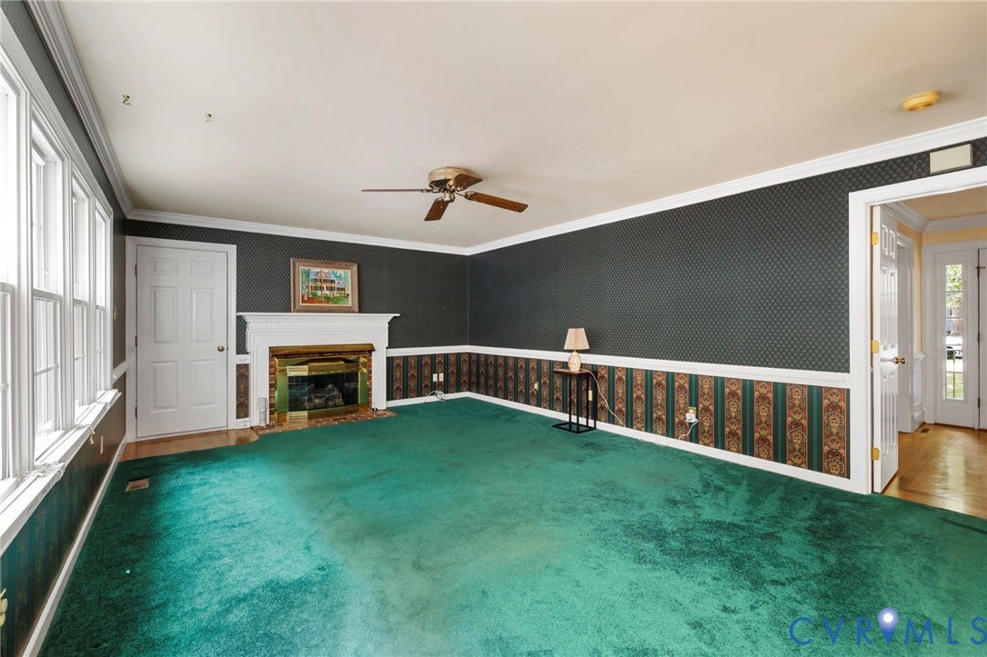 White window trim, white interior door, white fireplace mantel, ceiling fan, and double doors with glass panels