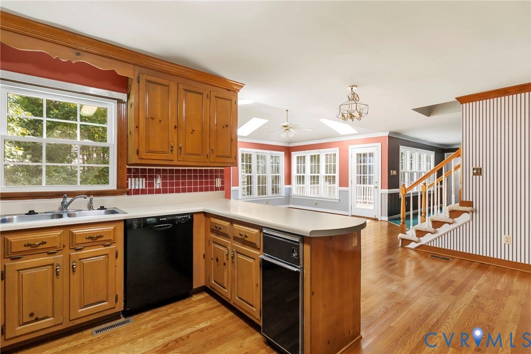 Kitchen featuring wood cabinetry, solid surface countertops, and an integrated dishwasher