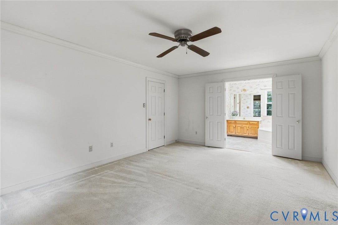 Recessed entry with double panel doors, crown molding, and ceiling fan