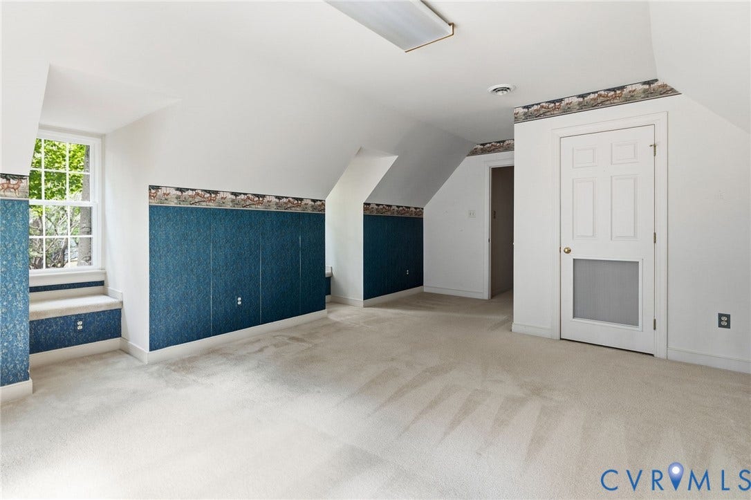 Light-toned carpeting, window with exterior views, interior door with lower screen, additional doorway