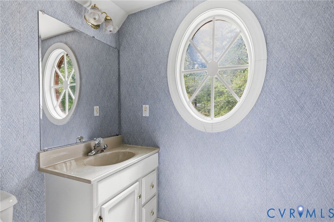 Vanity with integrated sink, chrome faucet, and white cabinetry
