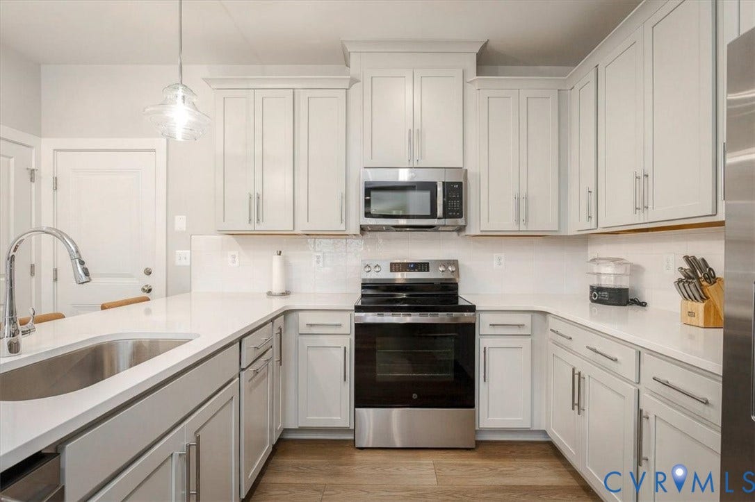 9690 Turning Point Dr, #A, 4E300, Glen Allen, VA 23059 U-shaped kitchen featuring stainless steel appliances, a tile backsplash and wood-finish flooring