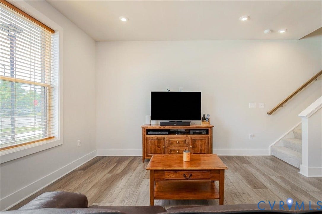 9690 Turning Point Dr, #A, 4E300, Glen Allen, VA 23059 Bright open-concept living area featuring wide-plank wood-finish flooring, recessed ceiling lighting, and abundant natural light from large windows with plantation shutters