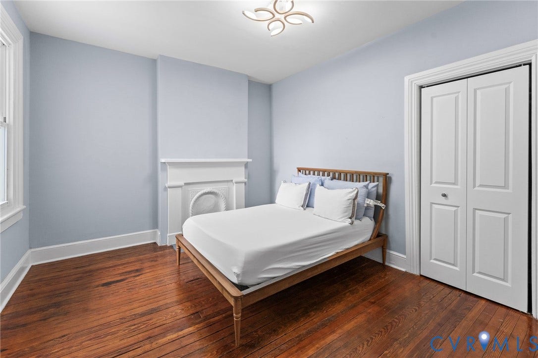 724 N 1st Street, Jackson Ward, Richmond, VA 23219 Hardwood flooring, painted walls, built-in bi-fold closet, ceiling-mounted light fixture, and a decorative fireplace