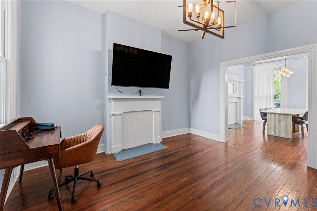 724 N 1st Street, Jackson Ward, Richmond, VA 23219 Hardwood flooring, decorative fireplace, cased openings, and a contemporary chandelier