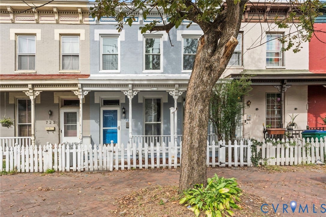 724 N 1st Street, Jackson Ward, Richmond, VA 23219 Brick exterior with a white picket fence, covered front porch, and decorative porch columns