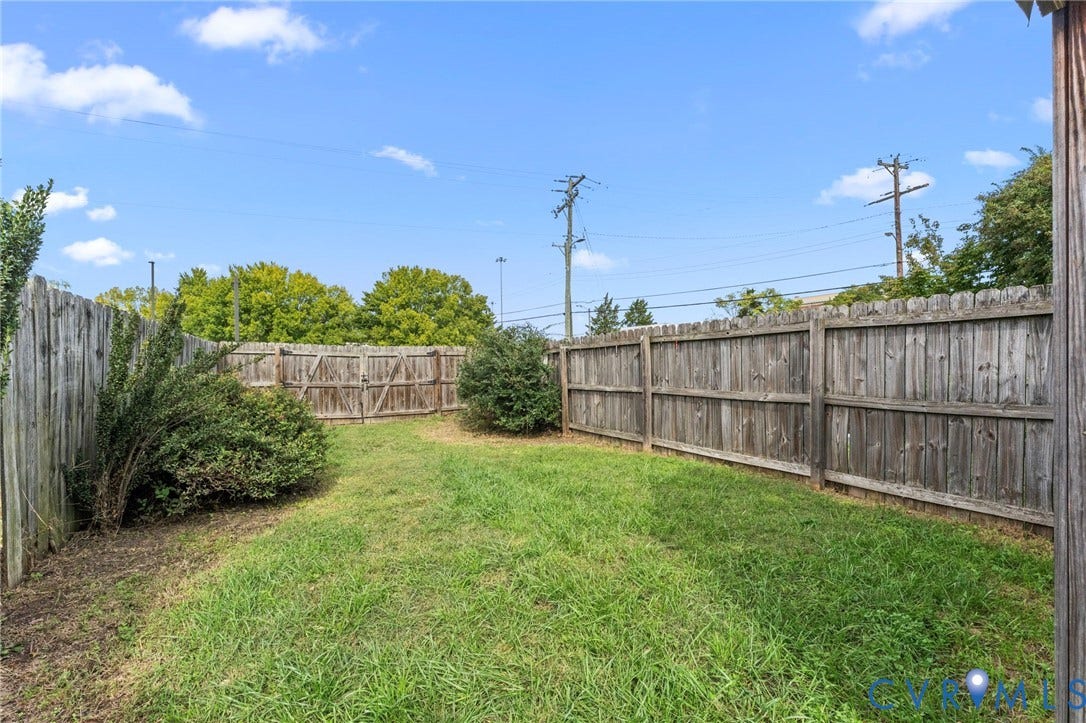 724 N 1st Street, Jackson Ward, Richmond, VA 23219 Grassed yard area, wood privacy fencing, established shrubs, and a wood gate