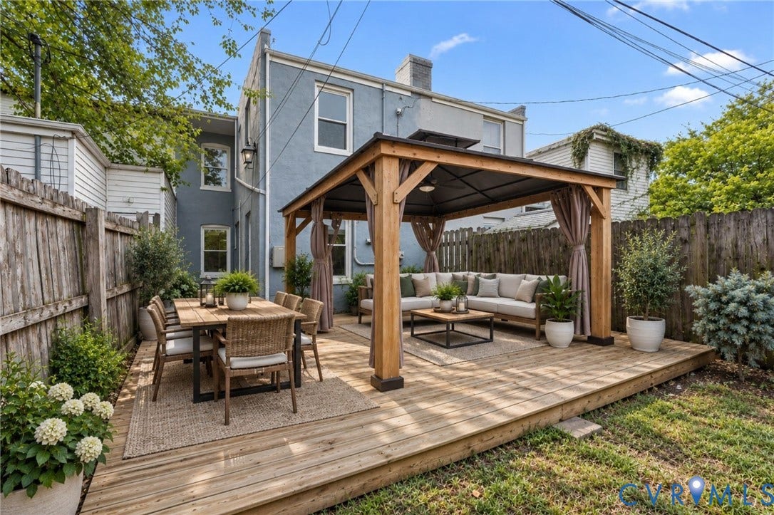 724 N 1st Street, Jackson Ward, Richmond, VA 23219 Expansive wood deck with a built-in pergola, outdoor lighting, and mature perimeter fencing