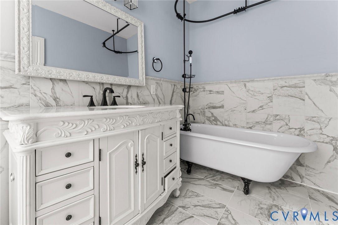 724 N 1st Street, Jackson Ward, Richmond, VA 23219 Carved white vanity with dark hardware, undermount sink, and a framed mirror