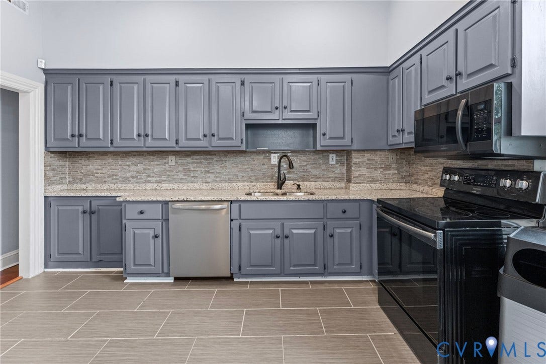 724 N 1st Street, Jackson Ward, Richmond, VA 23219 Gray cabinetry with black hardware, stone countertops, and a full-height tile backsplash