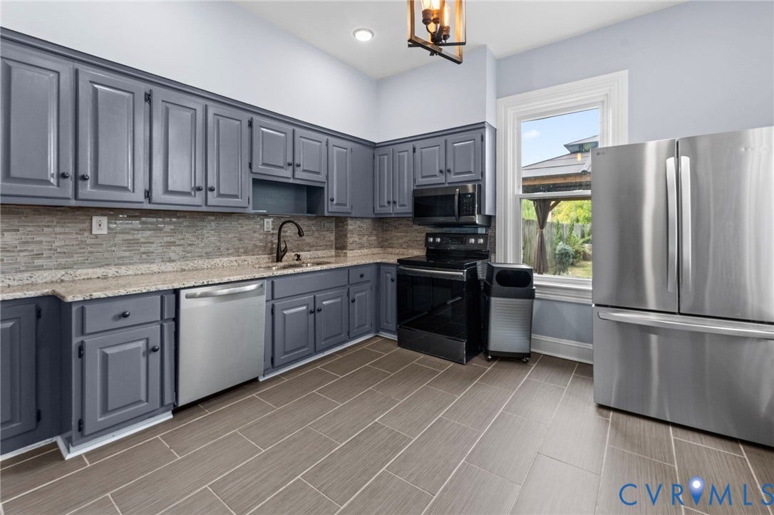 724 N 1st Street, Jackson Ward, Richmond, VA 23219 Gray cabinetry with black hardware, mosaic tile backsplash, light-toned countertops, tile flooring, and stainless steel appliances