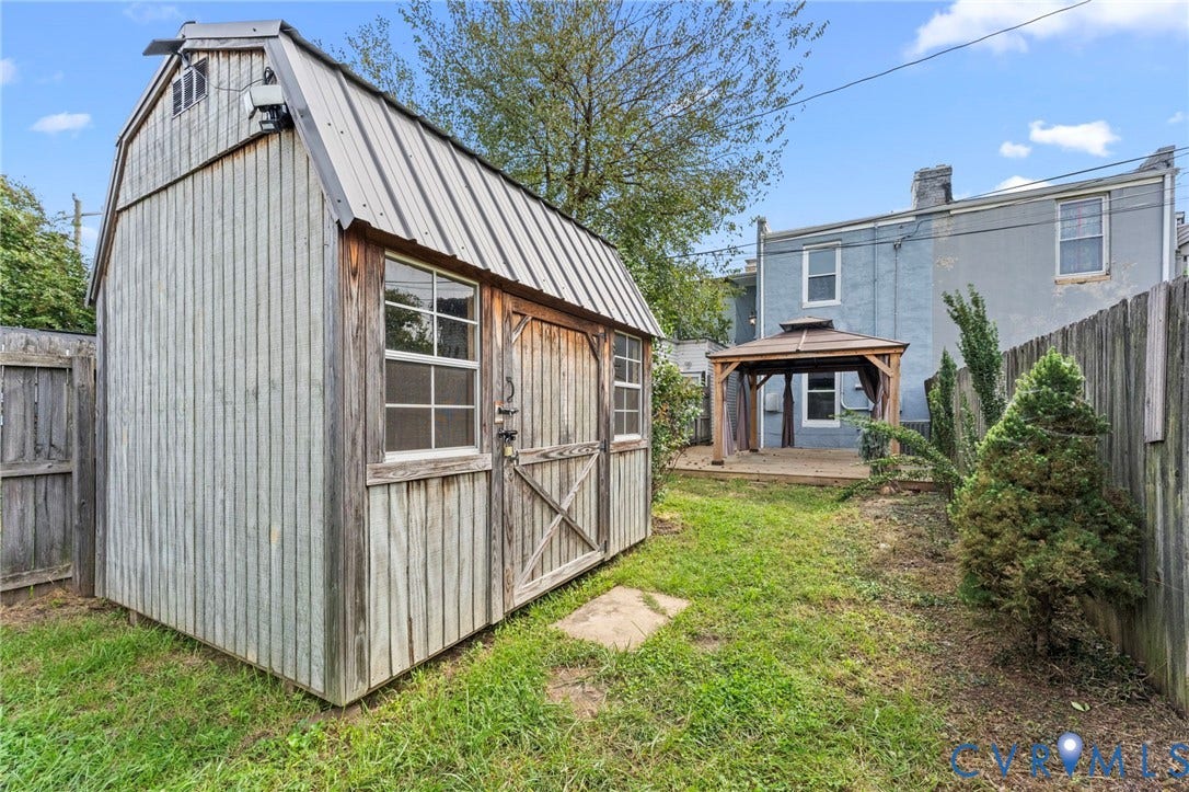 724 N 1st Street, Jackson Ward, Richmond, VA 23219 Backyard featuring a wooden shed with a metal roof, a wooden privacy fence, and a gazebo on a raised deck