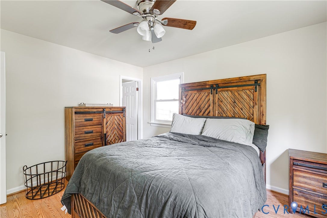 Hardwood-style flooring, white walls, and a ceiling fan with integrated lighting