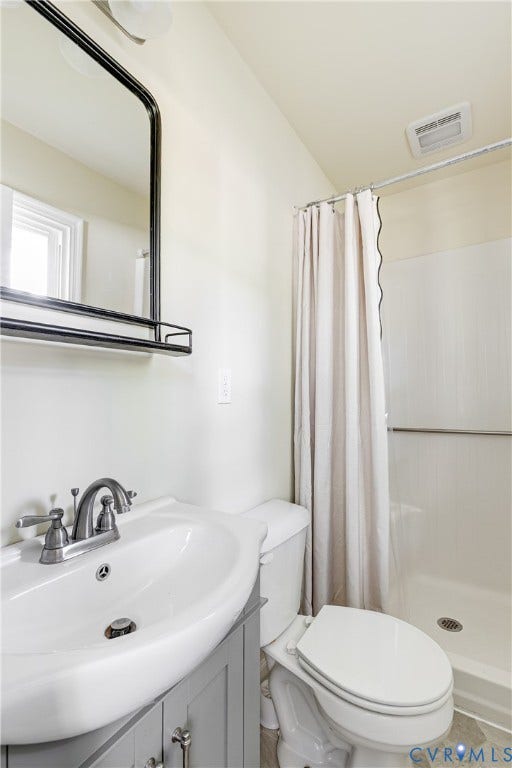 Pedestal sink vanity with a light gray finish, modern black-framed mirror with integrated shelf, and a shower with an integrated ceiling vent