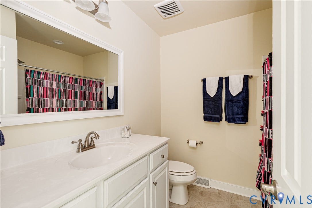 Single vanity with an integrated sink, brushed nickel faucet, and white cabinetry