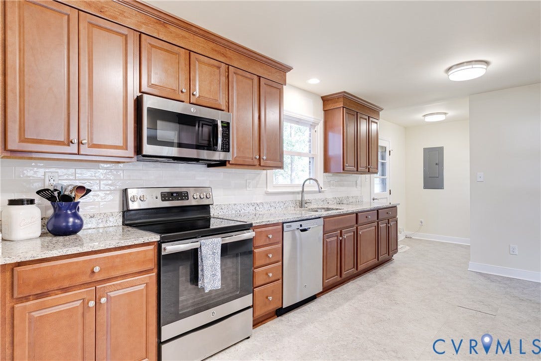 Wood-finish cabinetry paired with light-toned countertops and a subway tile backsplash