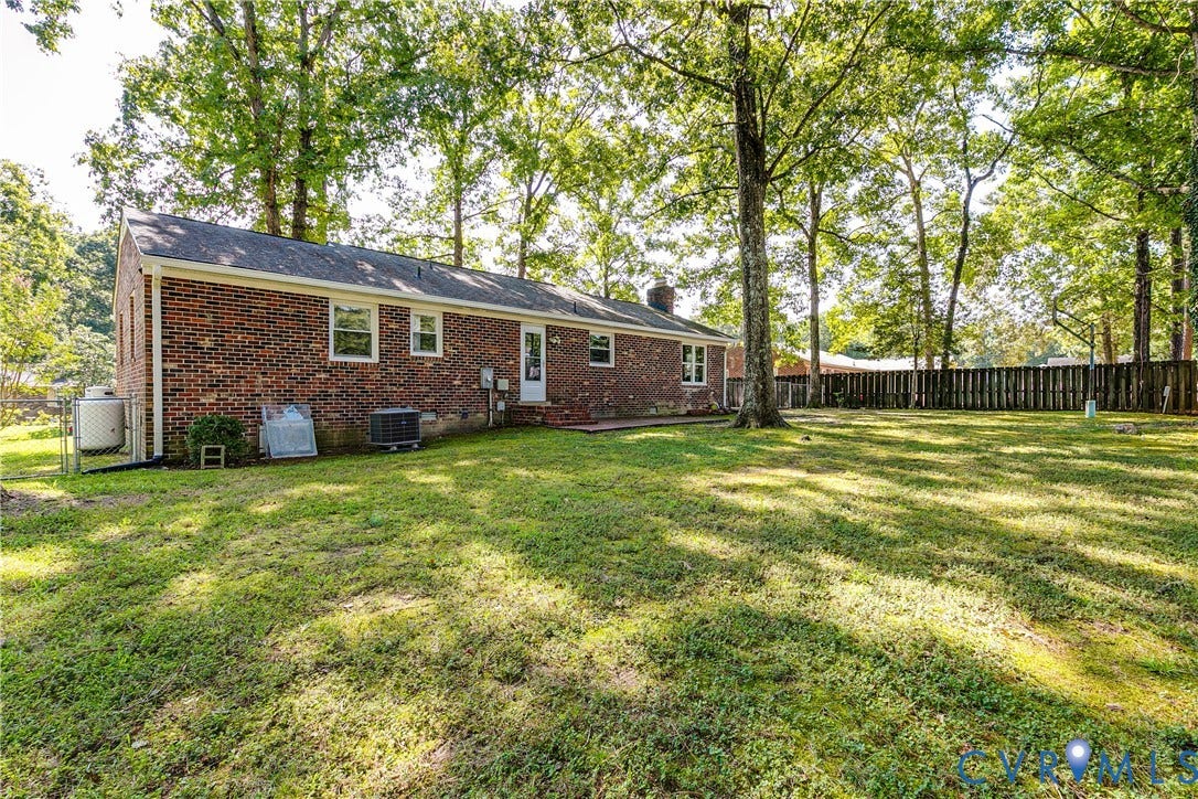 Brick exterior with multiple windows, leading to an expansive lawn area