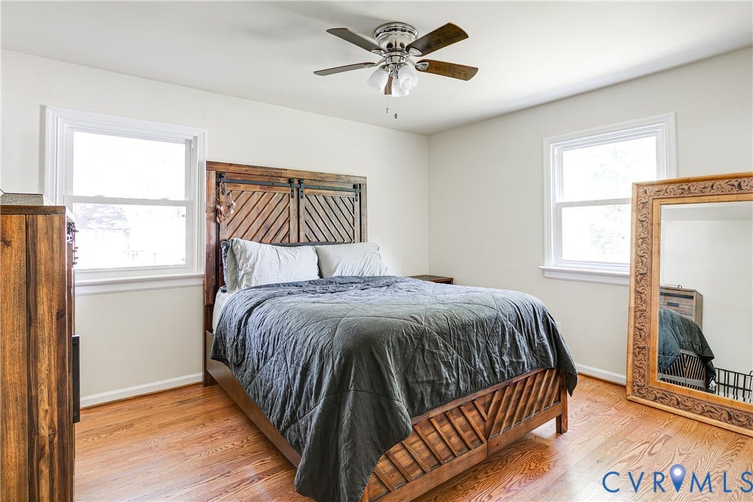 Hardwood flooring, painted walls, two windows, and a ceiling fan with light fixture