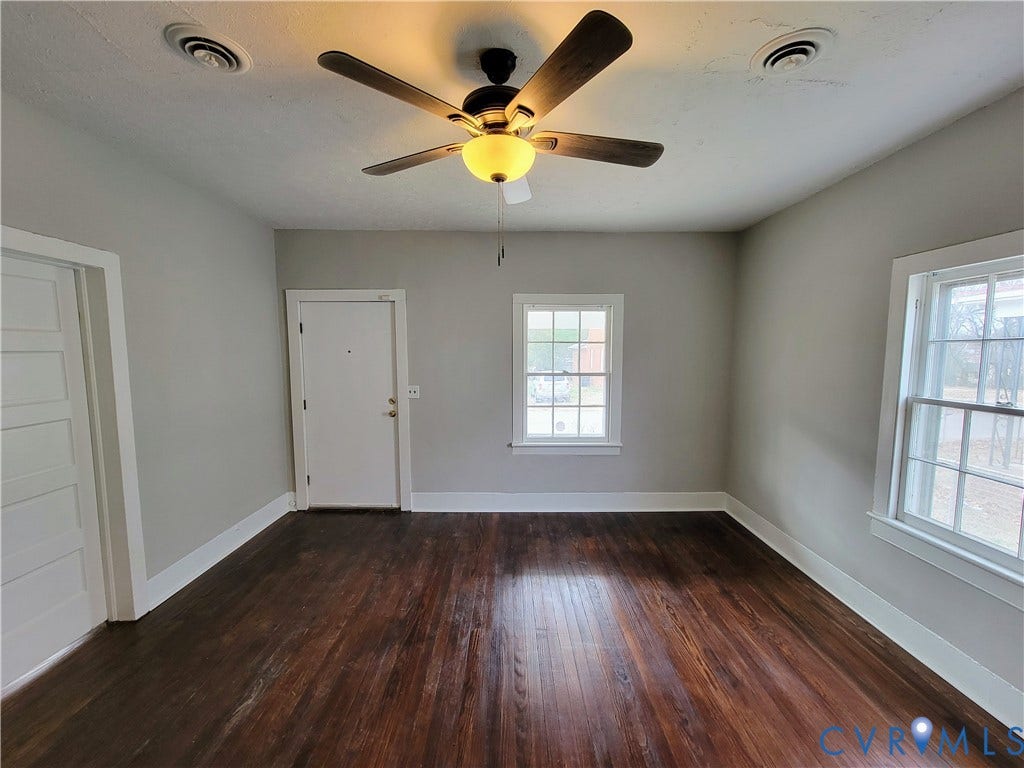 1223 Paul Street, Hillcrest, Petersburg, VA 23803 Spacious room featuring rich wood-finish flooring, neutral wall finishes, and abundant natural light from dual windows
