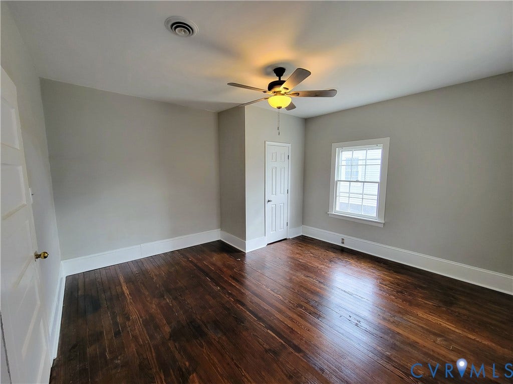 1223 Paul Street, Hillcrest, Petersburg, VA 23803 Rich wood-finish flooring, white trim, ceiling fan with integrated lighting, and a double-hung window
