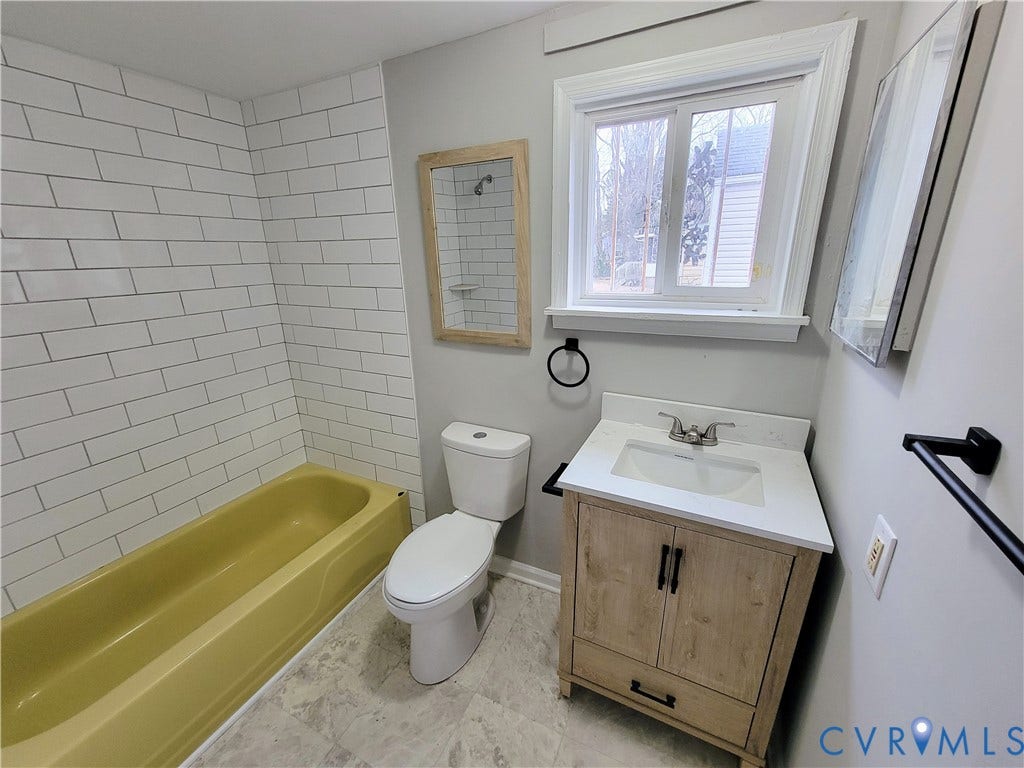 1223 Paul Street, Hillcrest, Petersburg, VA 23803 White subway tile shower surround, neutral vanity with wood-finish cabinetry, white countertop, and modern basin sink