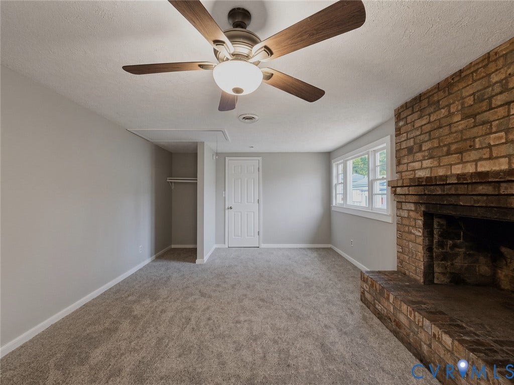 1223 Paul Street, Hillcrest, Petersburg, VA 23803 Brick fireplace, built-in closet with hanging rod, ceiling fan with integrated lighting, multiple windows, and plush carpet flooring