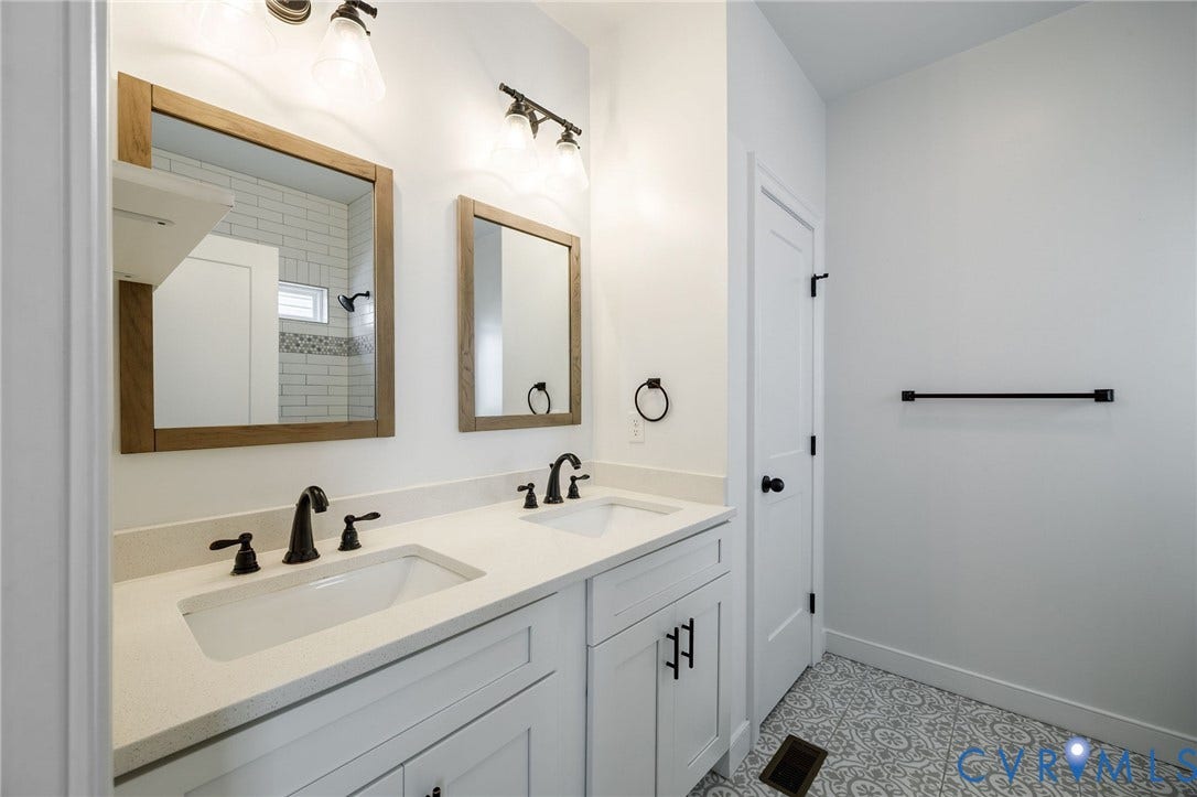 2902 Lawson Street, Richmond, VA 23224 Double vanity featuring white cabinetry, stone-composite countertops, rectangular under-mount sinks, matte black fixtures, and framed wood-finish mirrors
