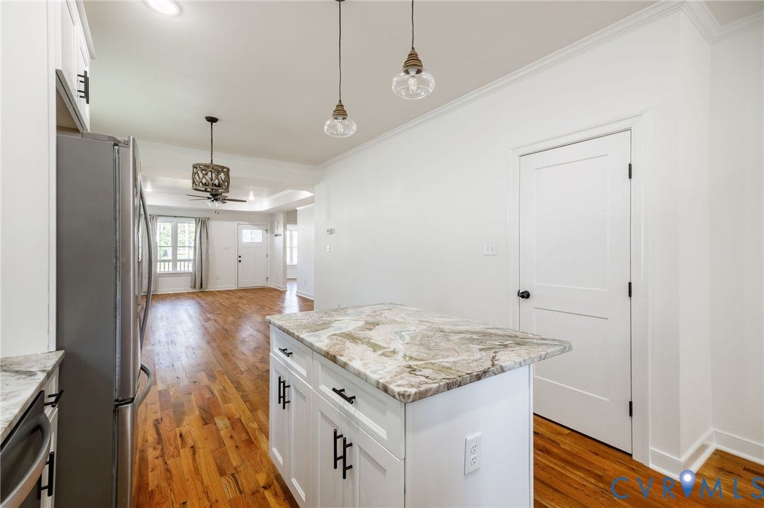 2902 Lawson Street, Richmond, VA 23224 Kitchen featuring white cabinetry, stone-surface countertops, wood-finish flooring, dual glass pendant lighting, and stainless steel appliances