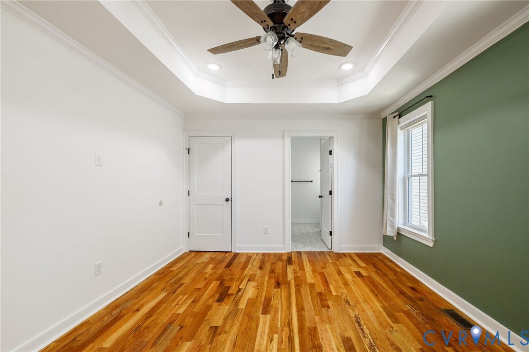 2902 Lawson Street, Richmond, VA 23224 Tray ceiling featuring crown molding, wood-finish flooring, multi-pane window with trim, and ceiling fan with integrated lighting